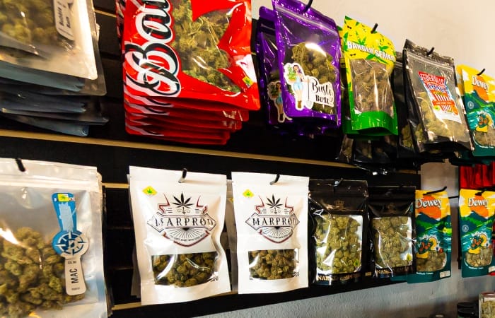 flower (3) cannabis flower packages displayed on wall of the dispensary